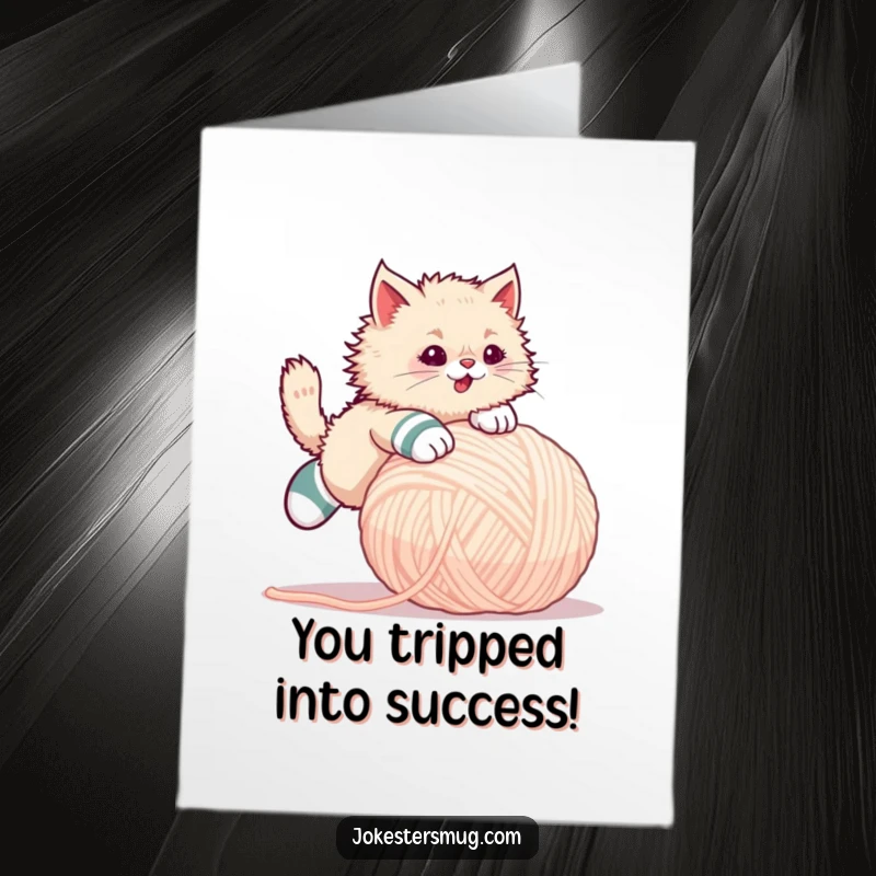 Funny Free Printable Congratulations Card: Cat wearing mismatched socks tripping over a giant yarn ball, humorous celebration.