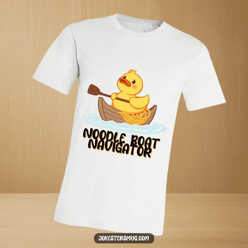 Funny confused rubber duck character trying to paddle a boat made of spaghetti, printed on a t-shirt.